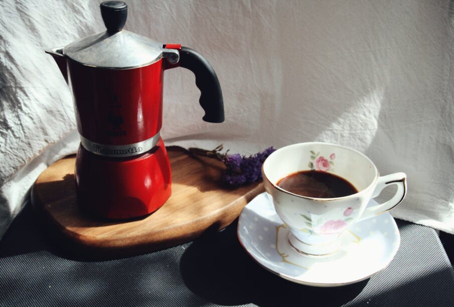 kırmızı moka pot ve bir fincan kahve